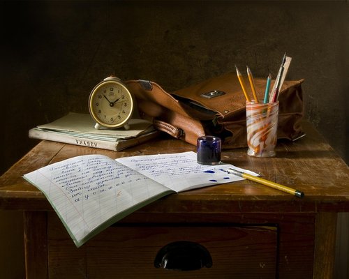 A desk setup with natural light and a small desk lamp for reading