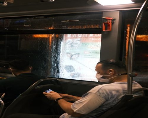 Commuters using smartphones in a brightly lit bus in Guadalajara